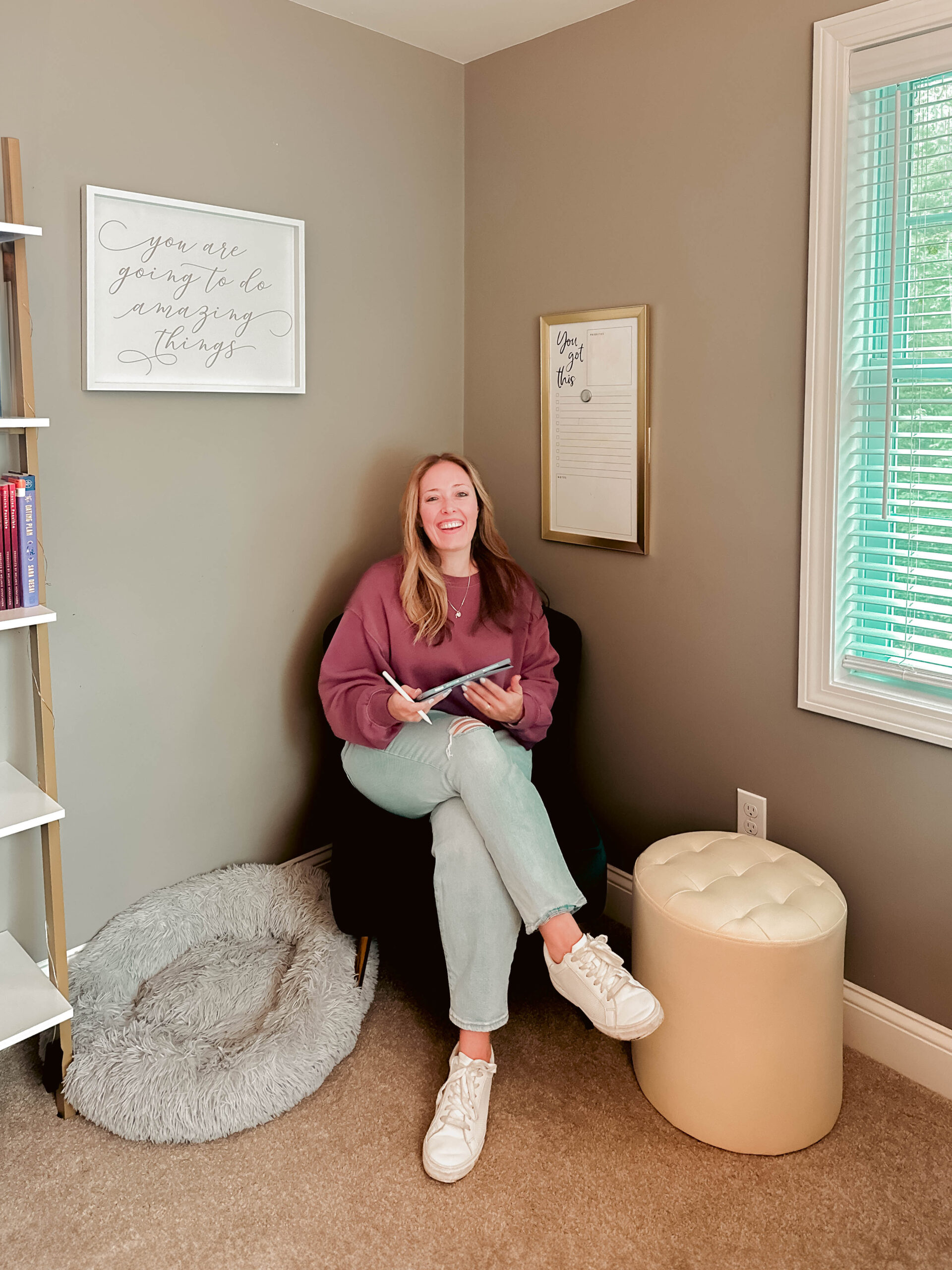 Photo of JennyB in the corner with an ipad and her apple pencil smiling